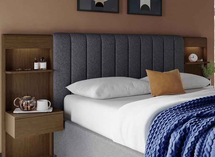 Hotel style bed with built-in bedsides, spotlights and shelves, with upholstery and wooden finishes.