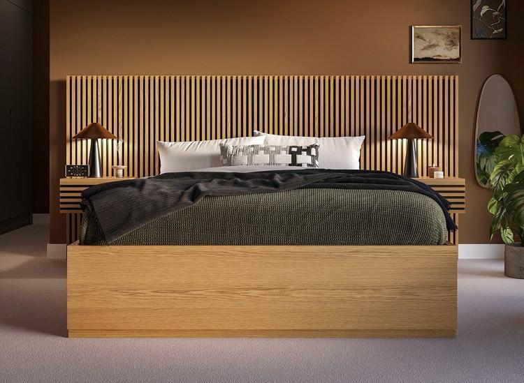 A hotel-style bed with wooden slatting and built-in bedside tables, styled against a brown wall.