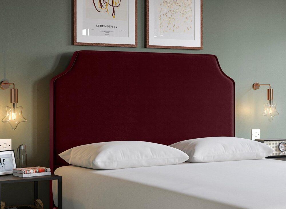 Deep burgundy tone headboard with notched corner design in a velvet-finish fabric