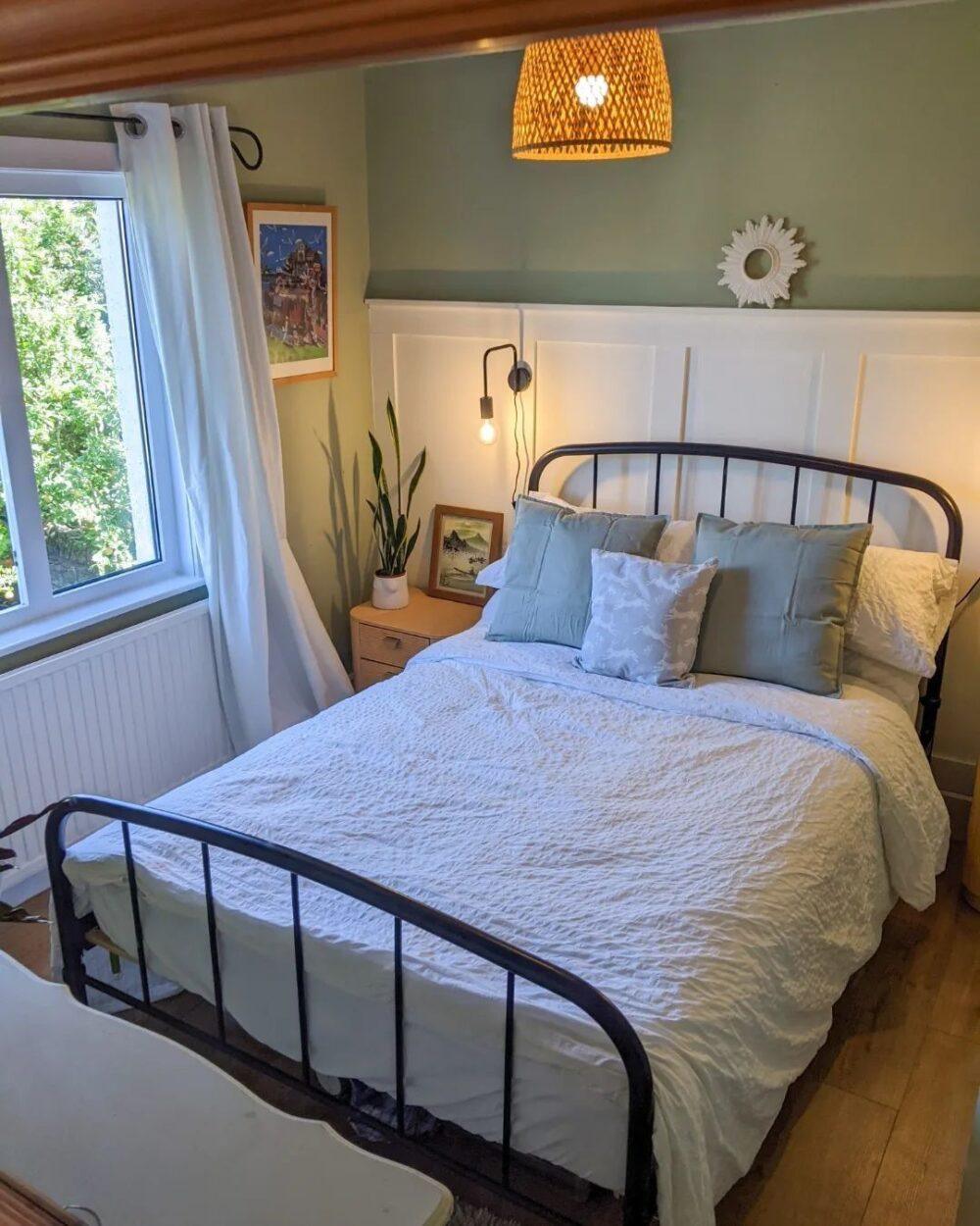 Green bedroom, black metal bed with white bedding