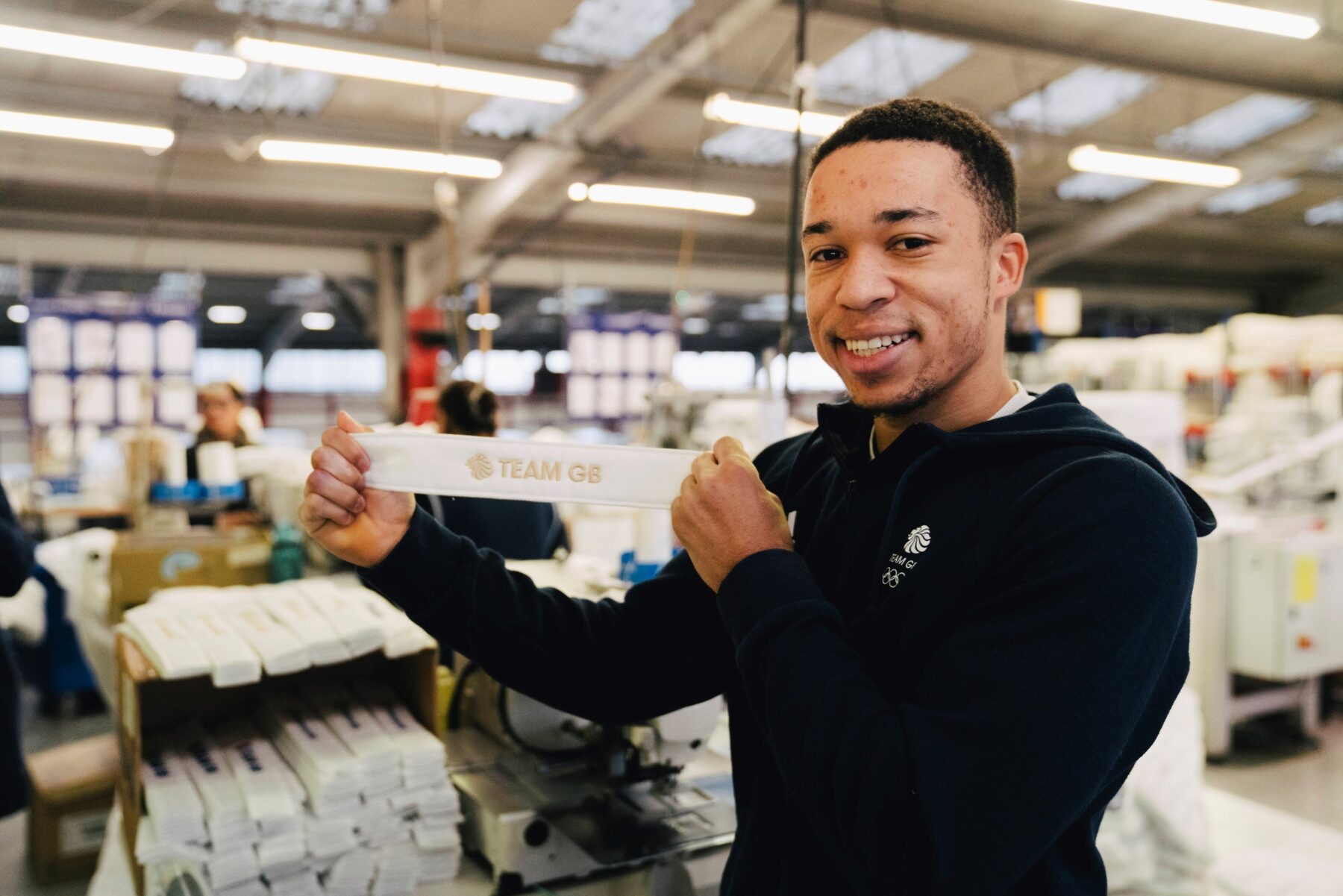 Joe Fraser holding a Dreams Team GB Gold label before it's attached to his mattress