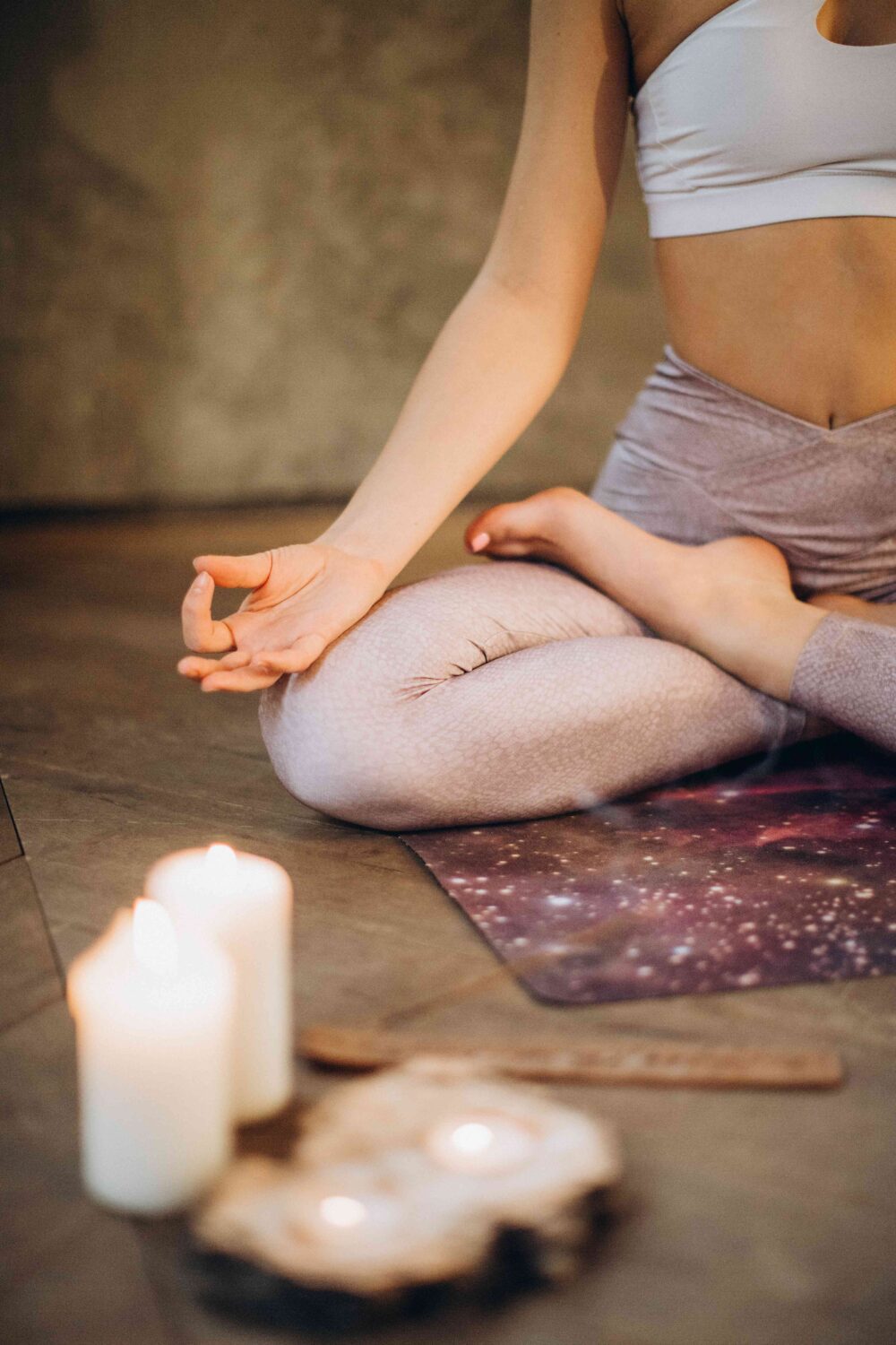 close up of meditating with candles in foreground