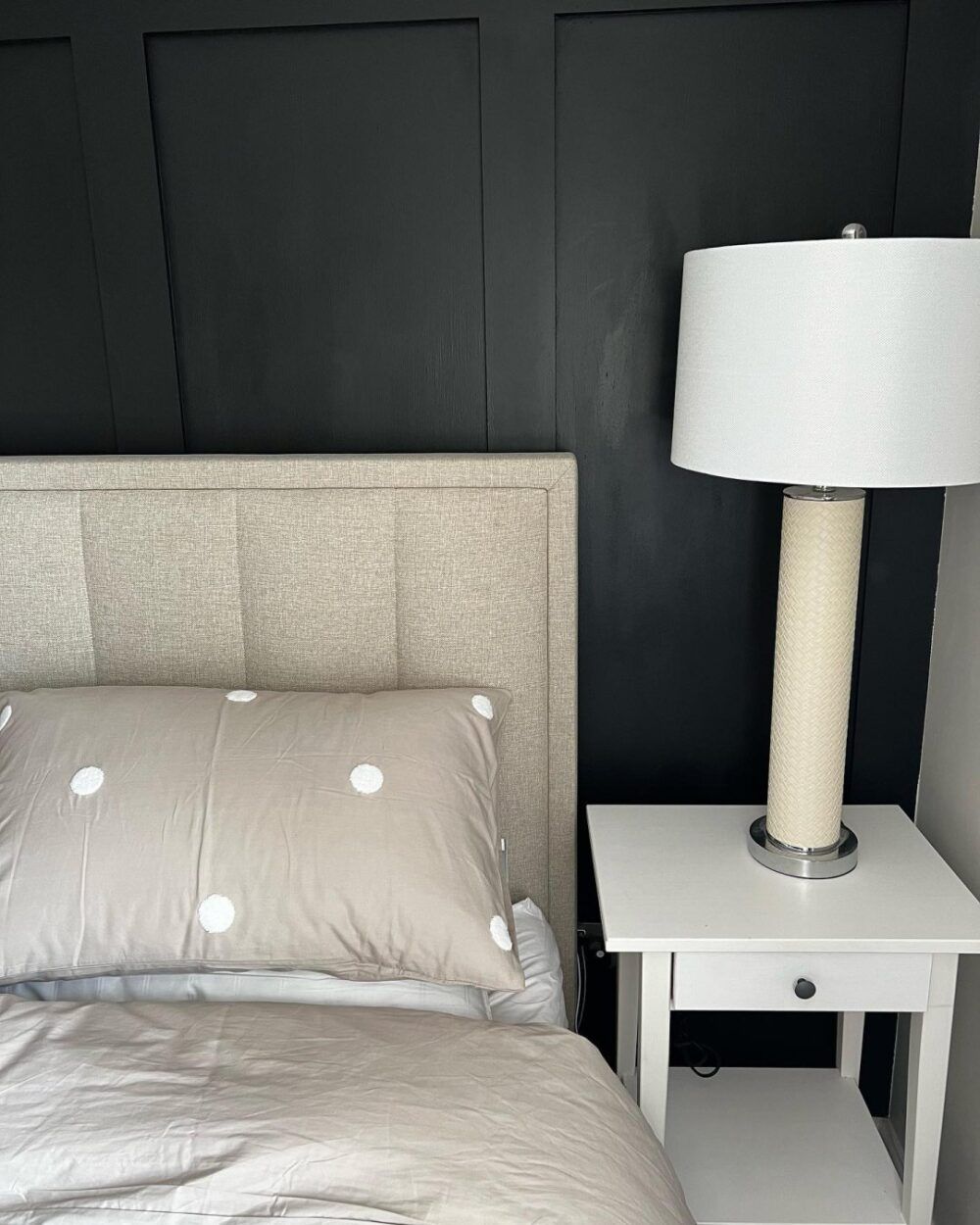 bedroom with navy blue wall panelling and grey bed frame