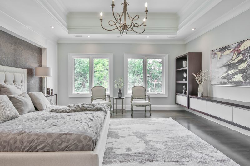 image of bedroom with chandelier and wall panelling to show neo-classical bedroom design trend