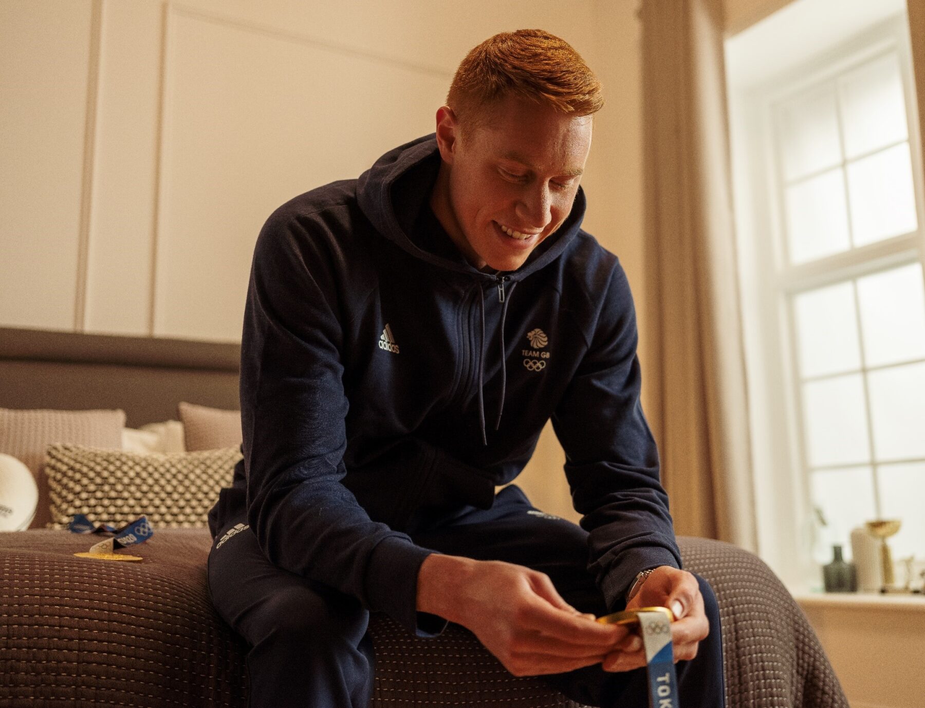 Tom Dean MBE, pictured in his Dreams bedroom with a medal